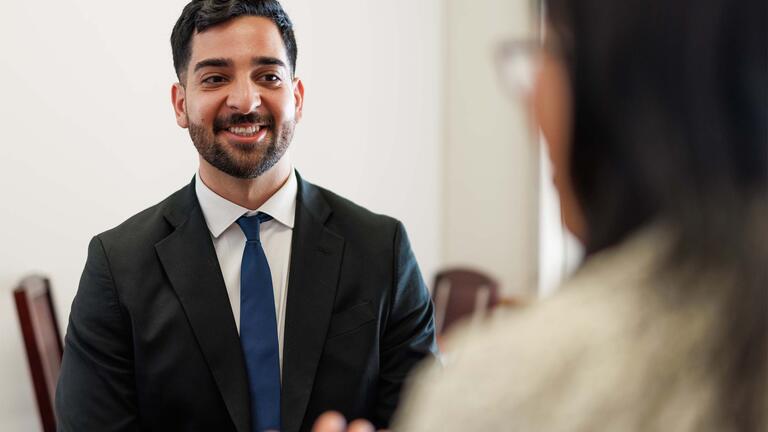Person in a suit talking with another person