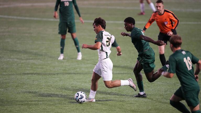 soccer player runs with ball during match