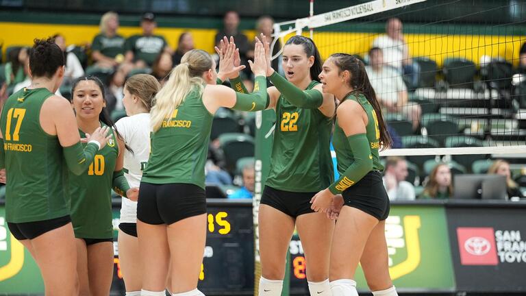 volleyball players give each other high fives during game