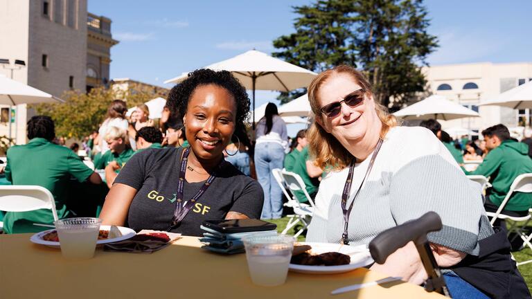 Two students smiling at an outdoor USF event