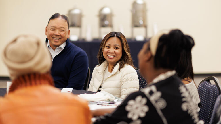 Students seated around a table, chatting
