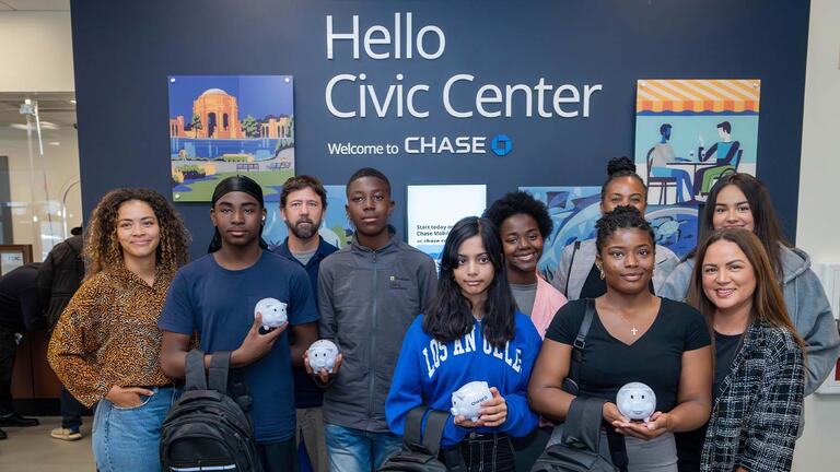 Students standing in front of a wall that says "Hello Civic Center"