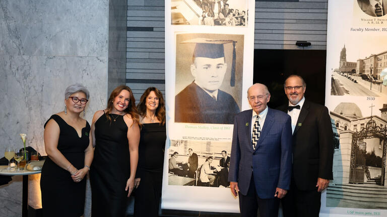 Alumnus Thomas Malloy ’61, and his family with his yearbook photo at the gala’s walk through history gallery