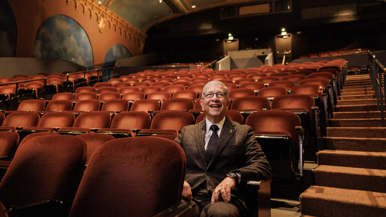 President Aceves sitting alone in Presentation Theater
