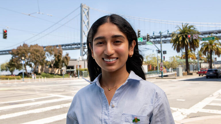 USF student posing in front of the Bay Bridge