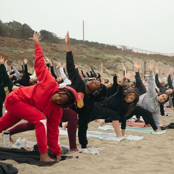 People doing yoga on the beach