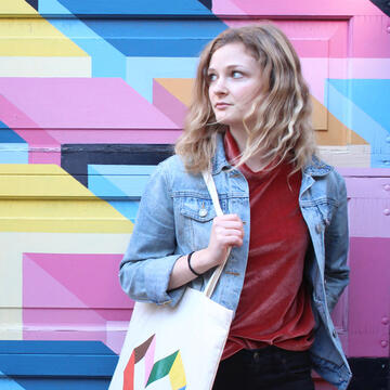 Madeline Warner in front of a mural.