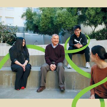 Joseph Nguyen seated in an amphitheater with students.