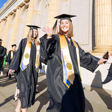 students waving at commencement