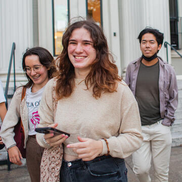 Several students walk down the steps of USF's Masonic building, outside the McCarthy Center