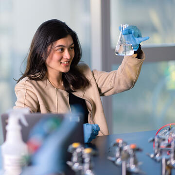 student examines a lab beaker