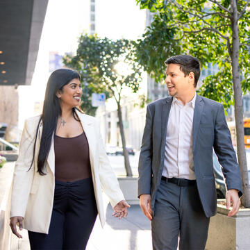 Two USF students walking outside and chatting in business attire