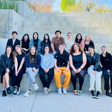 Group of students pose sitting on stairs.