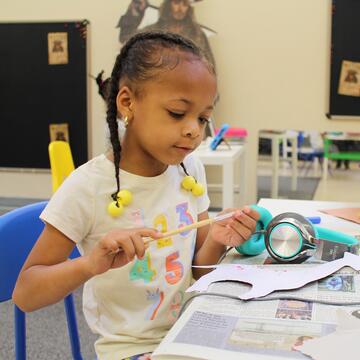 elementary school student holding paintbrush