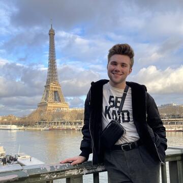 a student standing in view of the Eiffel tower