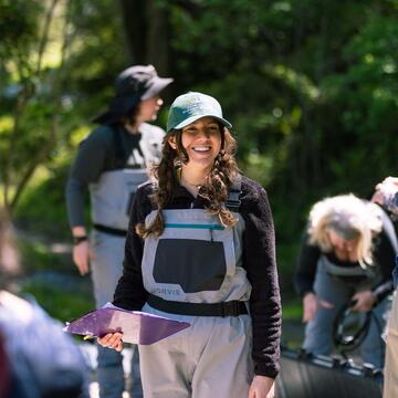 Student smiling outdoors with other students around