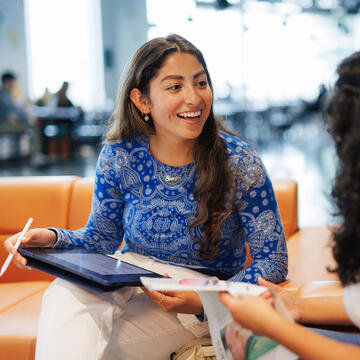 USF student in blue sweater chatting with a friend