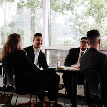 Four people posing in business attire.