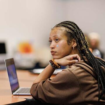 Student sitting at a table with a laptop