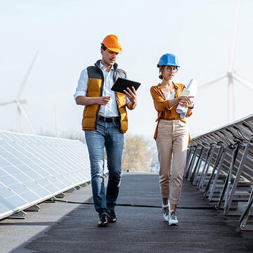 two people walking along a solar farm