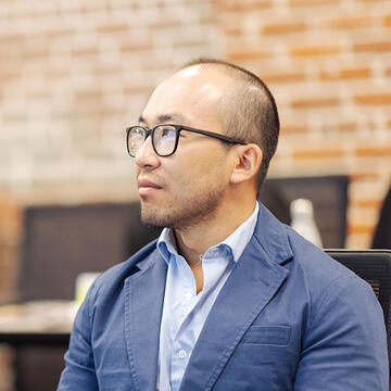 student with glasses and suit sitting in class