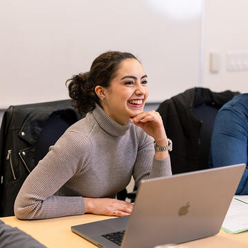 Student laughing at computer