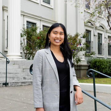 Urban & Public Affairs student in front of a building.