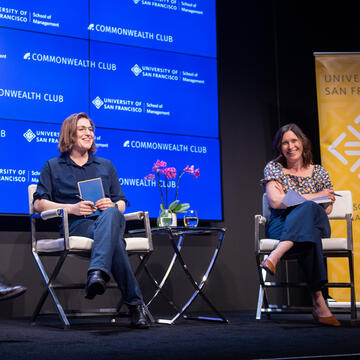 two panelists on stage during symposium