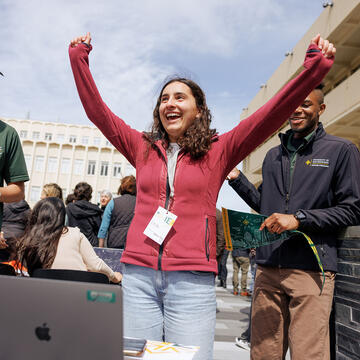 Student raising arms in triumph.