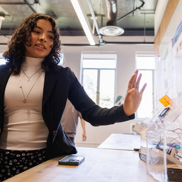 An engineering student shows her project in class