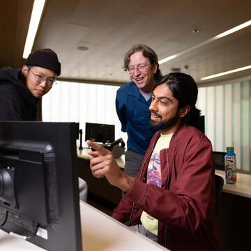 two students and prof. brooks in the computer lab
