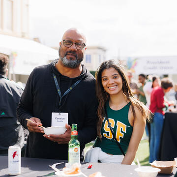 father and daughter eat together on campus