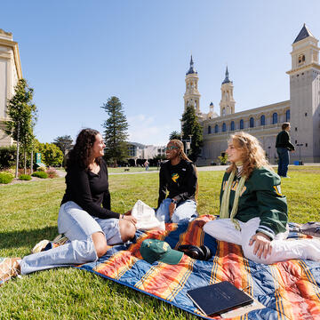 students sitting on grass