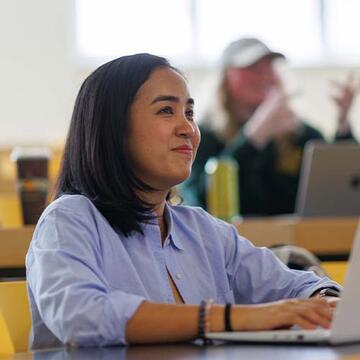 Student with a laptop in lecture