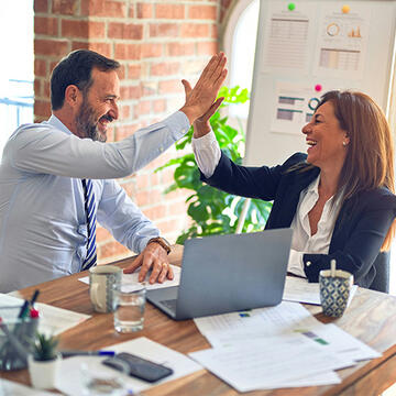 Two working professionals high-fiving each other