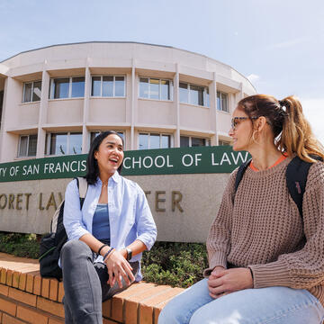 Two USF law students chatting outside the law building