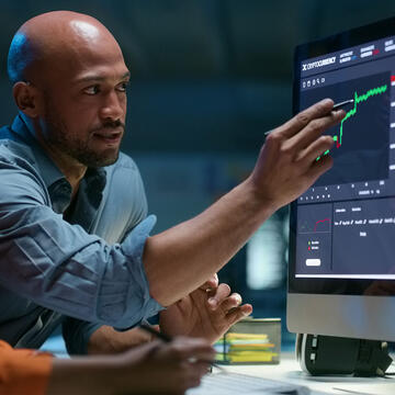 Analyst points to data graph on a screen