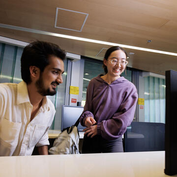 Two USF students smiling in computer lab