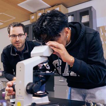 Student looking into a microscope