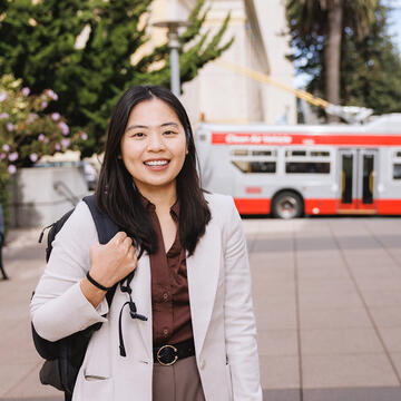 student stands in front of muni stop