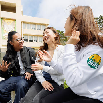 students laugh together outside on campus