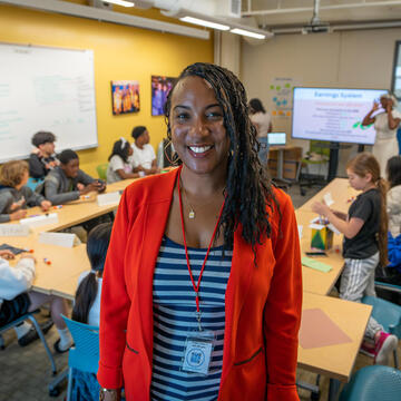 Michelle Hector standing in a classroom of children