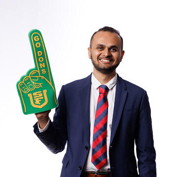 USF employee smiling, holding foam "Go Dons" pointing hand
