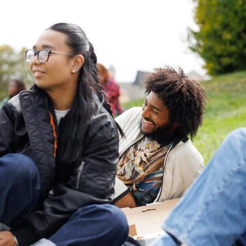 students laying in grass together on usf campus