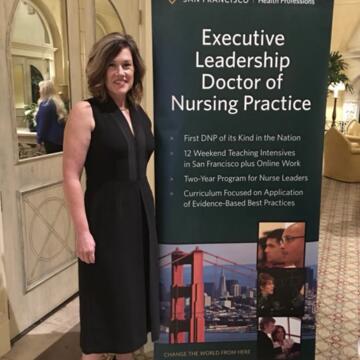 Kimberly Perris next to a USF nursing leadership sign
