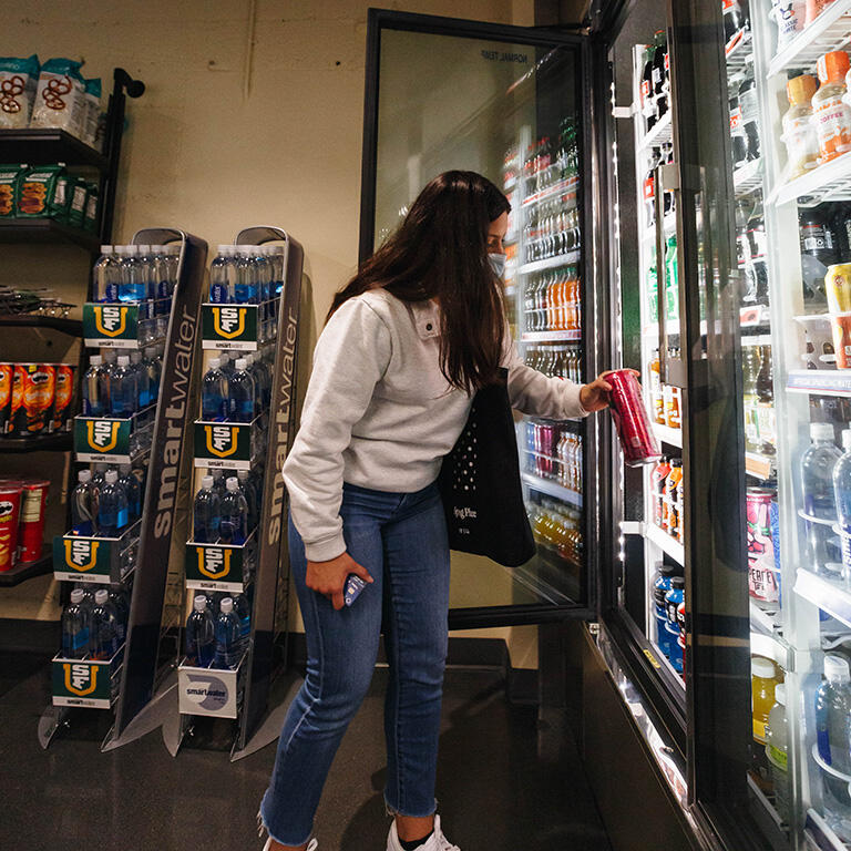 student reaches for drink