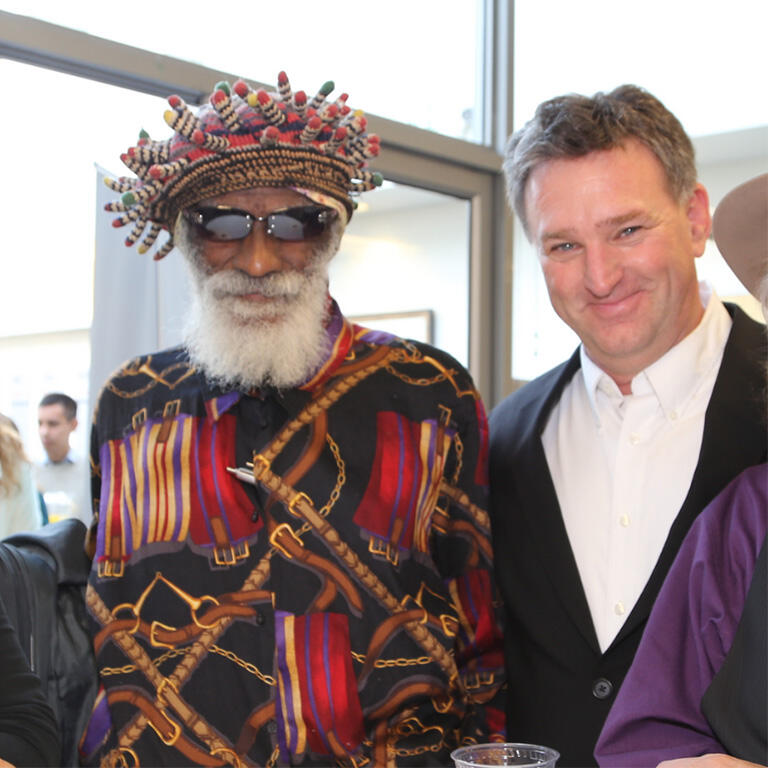 Two people standing side by side, smiling for a photo