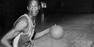 Bill Russell dribbling on a court.