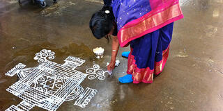 Woman painting the ground — Image credit: Pichammal Nagarajan kōlam, TedX GoldenGate, Crane Pavillion, Richmond, CA 2011. Photo: Lee Swenson