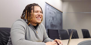 student sitting in classroom in front of laptop